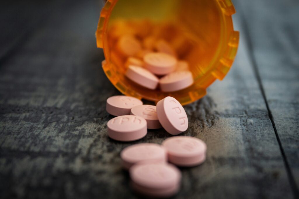 Pill bottle of prescription drugs spilled out on the counter. Prescription Drug Misuse