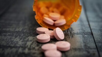 Pill bottle of prescription drugs spilled out on the counter. Prescription Drug Misuse