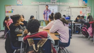 classroom with students lookin gat teacher in front of white board
