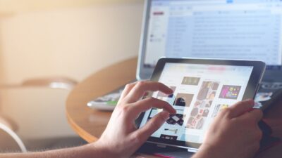 person's hands phone tablet laptop
