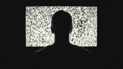 male in front of tv with static on screen