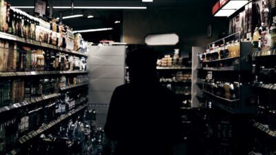 teen in hoodie in liquor store aisle